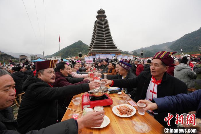 12月15日,在广西龙胜各族自治县乐江镇江口村,侗族群众在鼓楼前摆起“百家宴”欢度侗年。 韦吉阳 摄